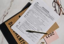 Formularz podatkowy z długopisem i okularami na marmurowym blacie