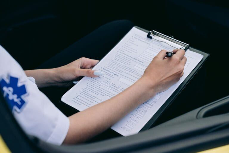 Ratownik medyczny sporządzający notatki na clipboardzie w samochodzie
